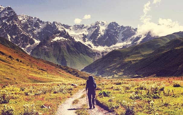 man hiking in valley with mountains