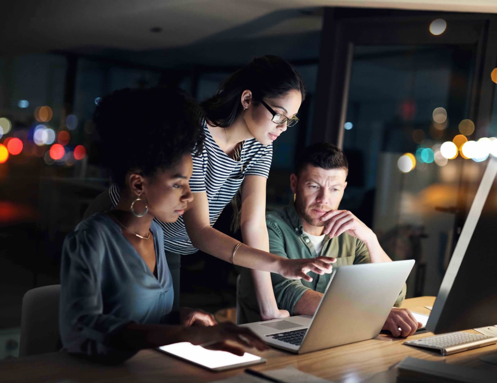 Shot of a group of designers working late on a laptop in an office