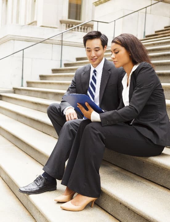 couple on steps of government building looking at laptop