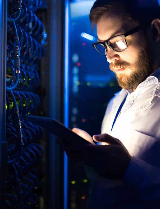 IT worker looking inside a data center cabinet