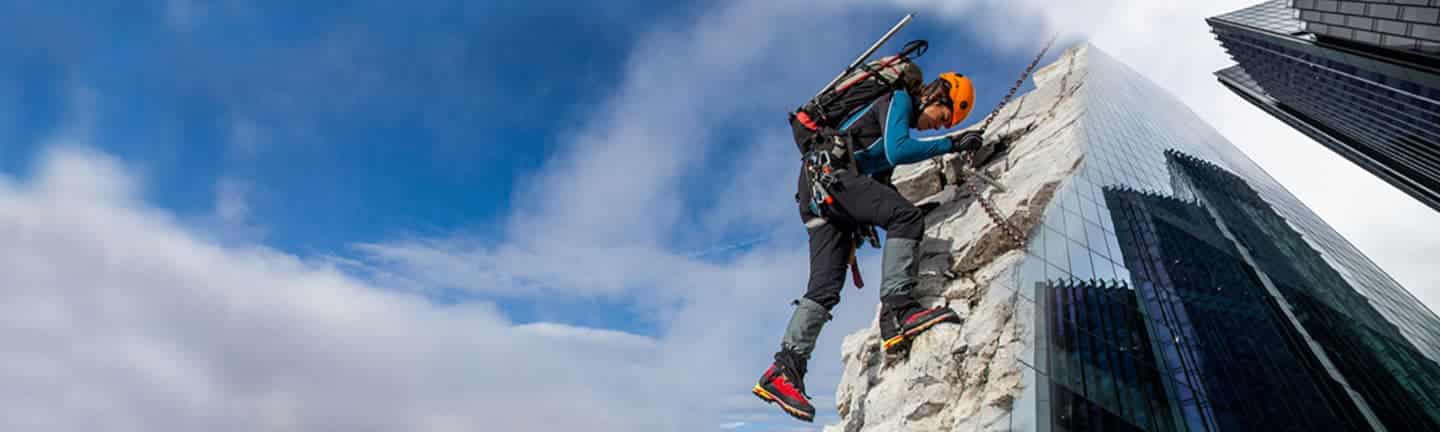 person climbing a rock that turns into a skyscraper