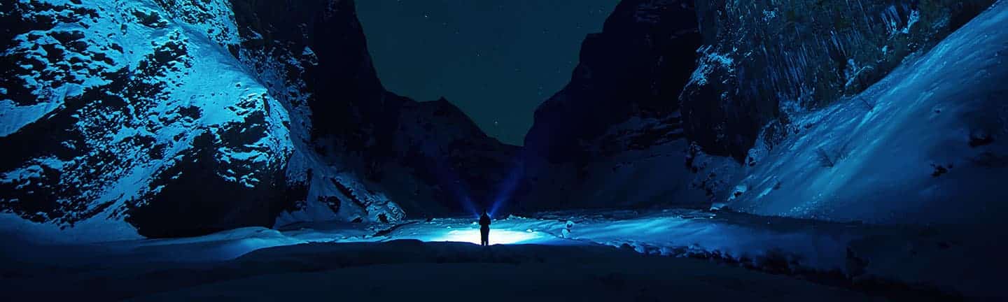 person standing in valley of snowy mountain