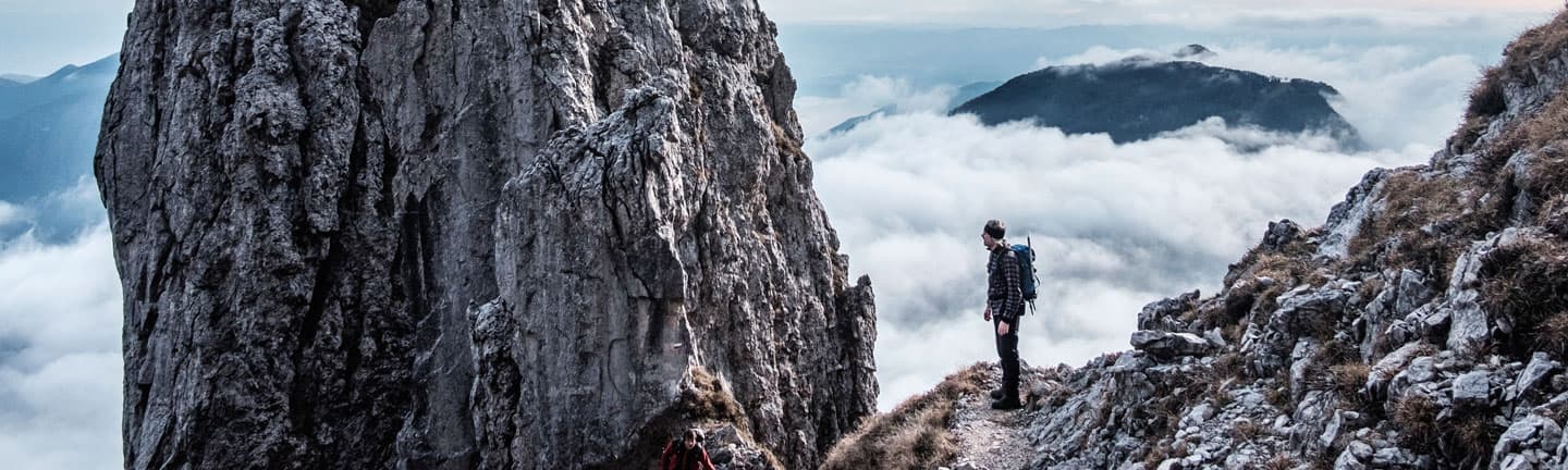 man standing on rock cliff