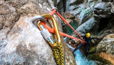 climber secured by caribiners as he belays