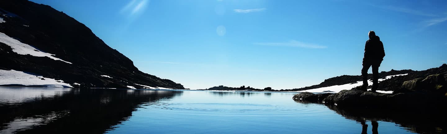 person standing at edge of lake