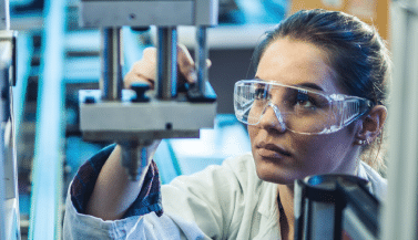 woman looking at manufacturing equipment