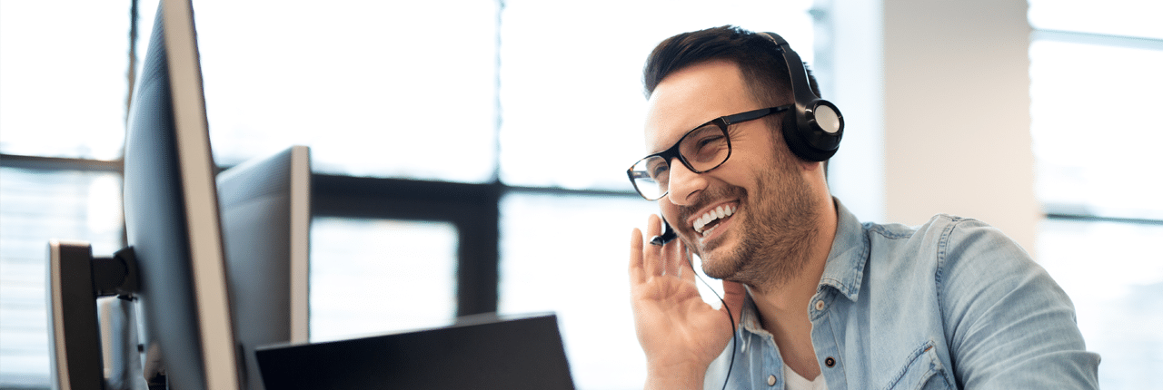 man-talking-on-headset-in-front-of-computer